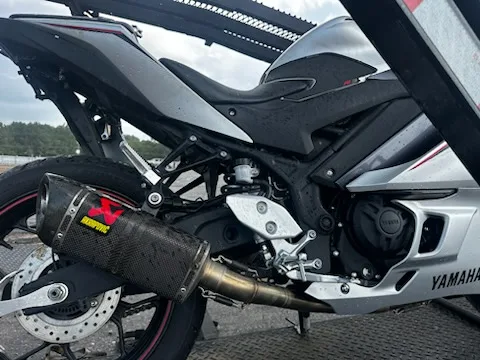 Yamaha R3 with an Akrapovic carbon exhaust secured on a motorcycle transport trailer