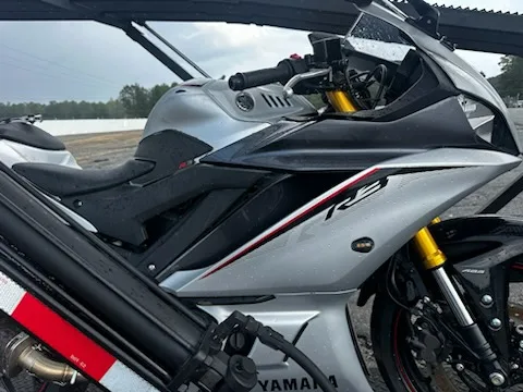 Side view of a silver Yamaha R3 motorcycle loaded on a transport trailer deck